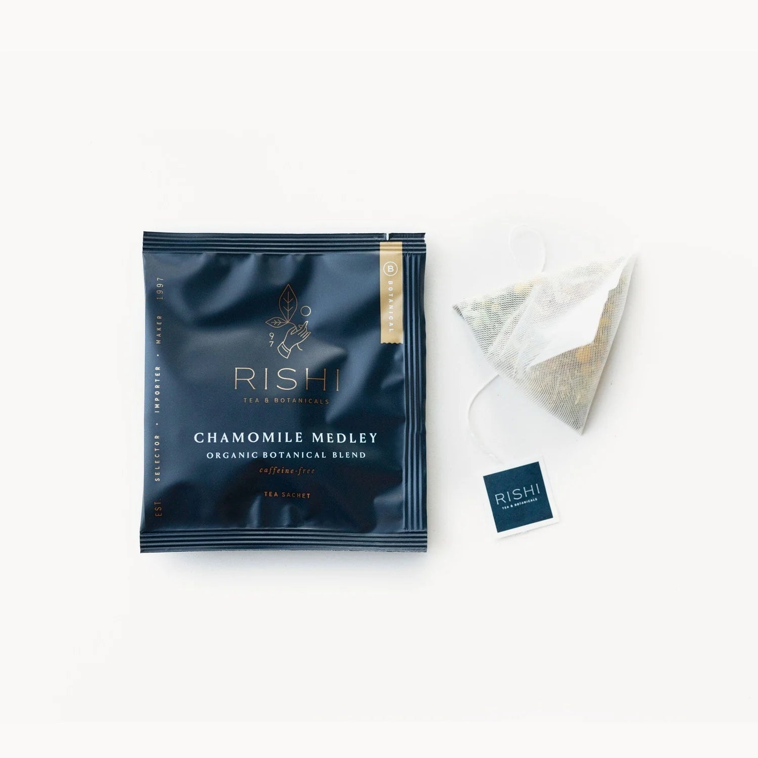 A packaged tea bag labeled 'RISHI CHAMOMILE MELODY' next to an unfolded tea bag and a price tag.