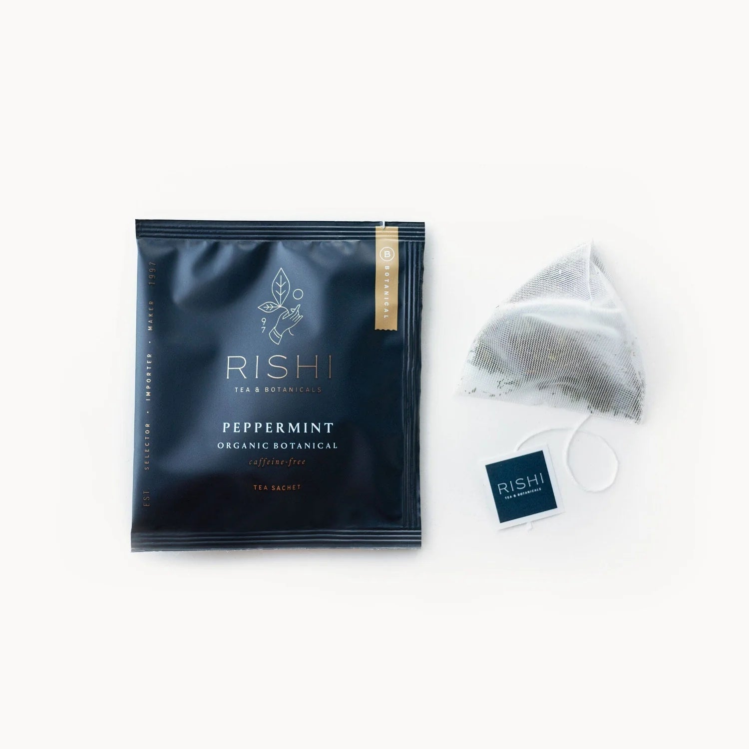 A packaged RISHI peppermint tea sachet alongside an individual sachet with visible peppermint leaves.