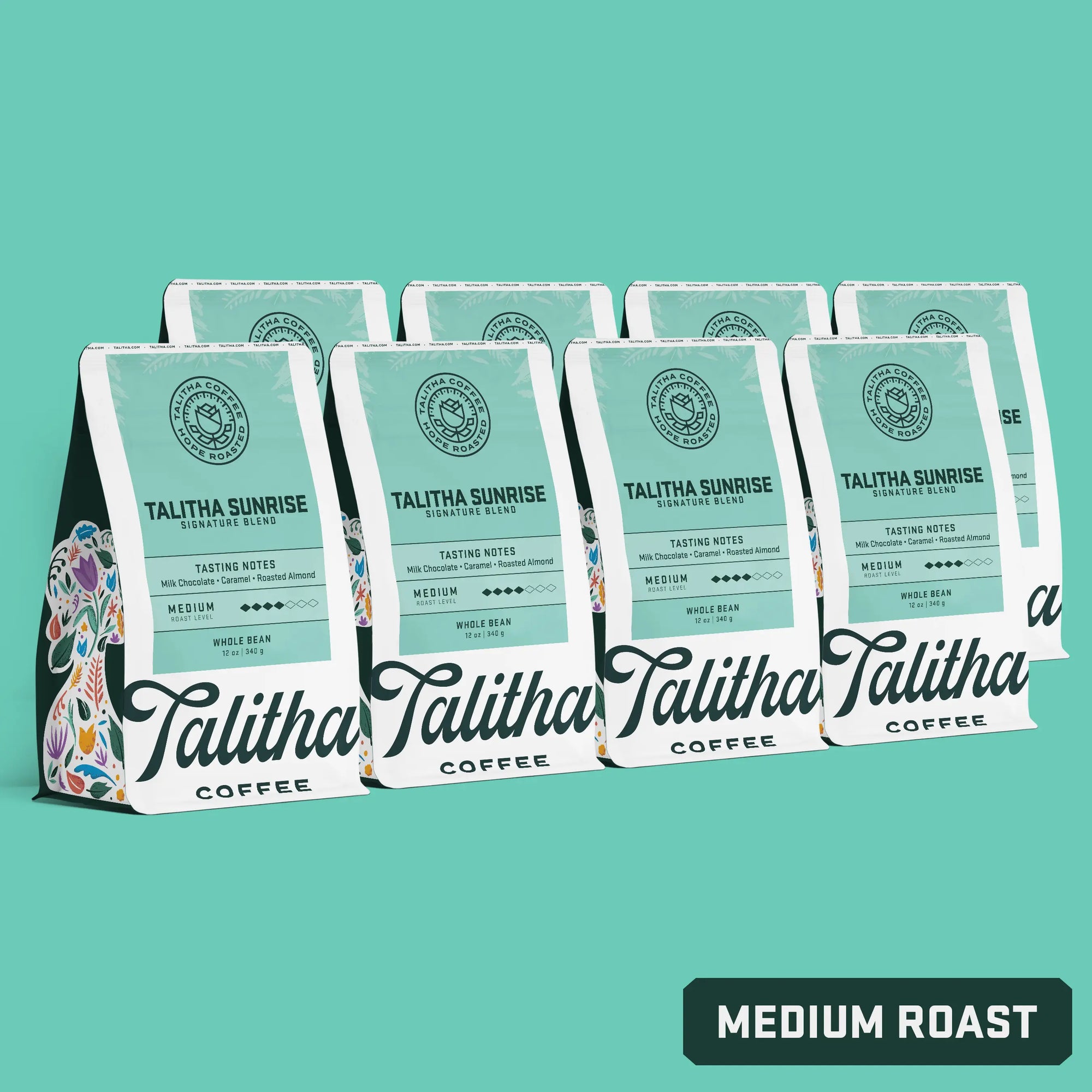 Multiple bags of 12oz Talitha Sunrise blend on teal background